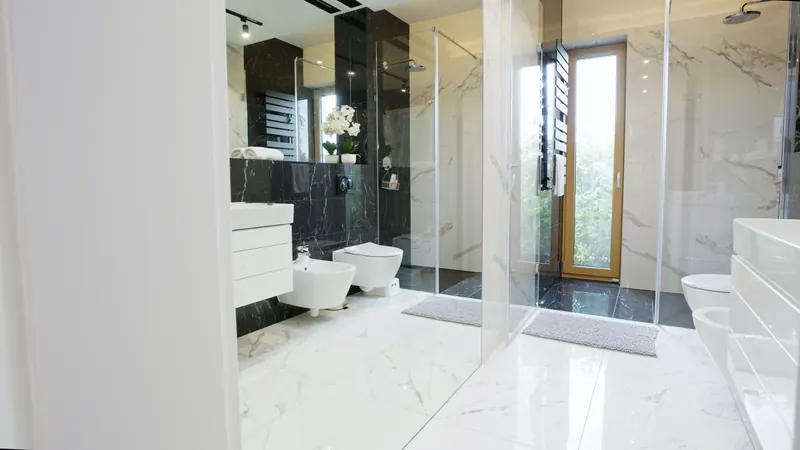Łazienka walk-in wykończona marmurem, z czarną armaturą